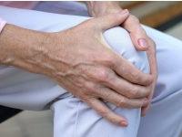 A woman holds her sore knee